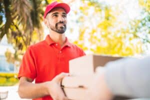 Courteous delivery person handing over packages outdoors.