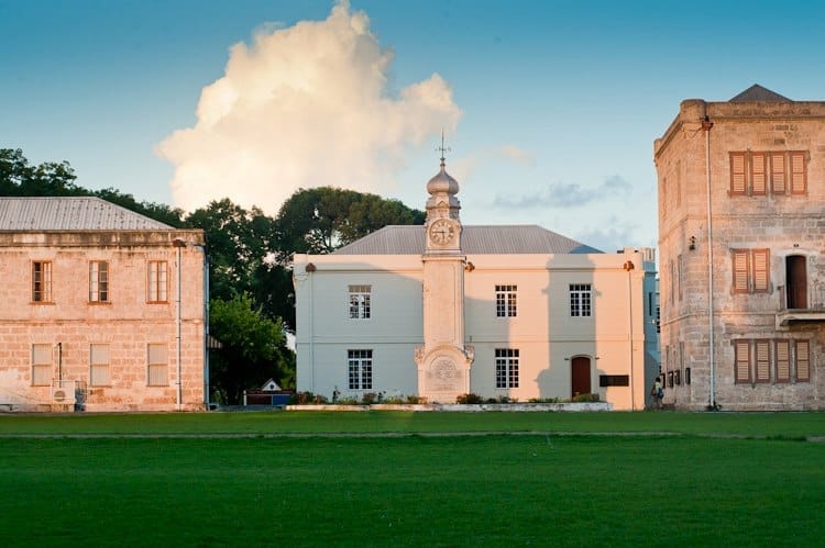 Historic clock tower building with grassy foreground.