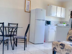 Modern kitchen and dining area with fridge and table.